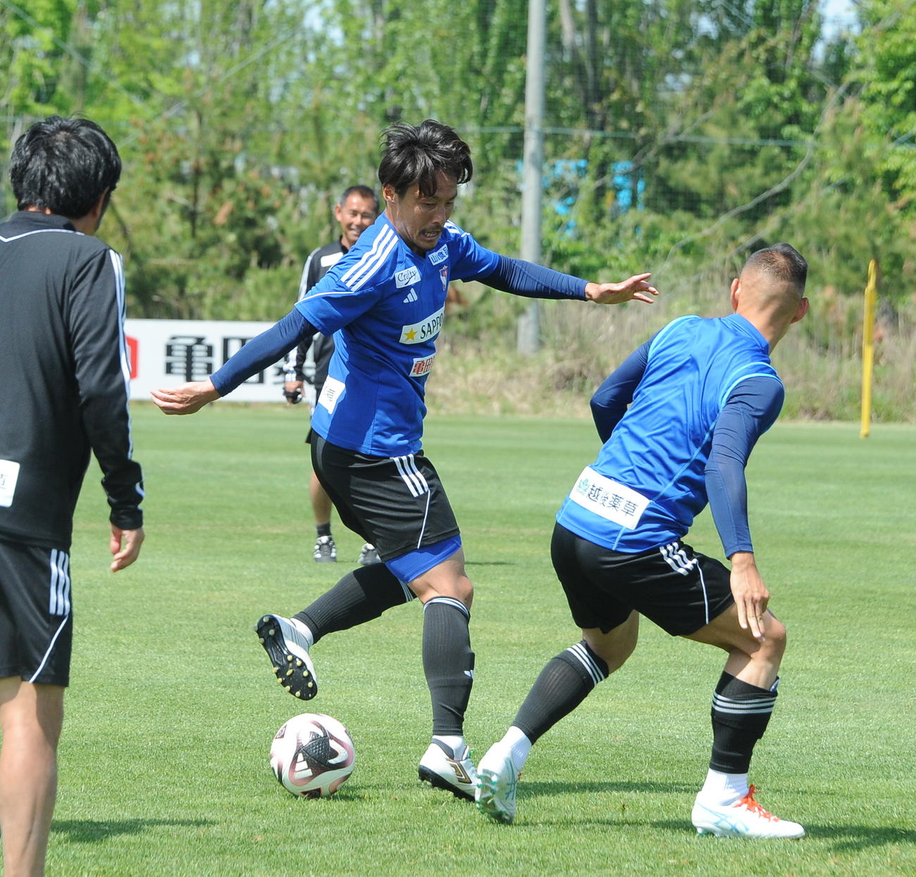 右足の後ろからパスを通す島田（右から2人目）