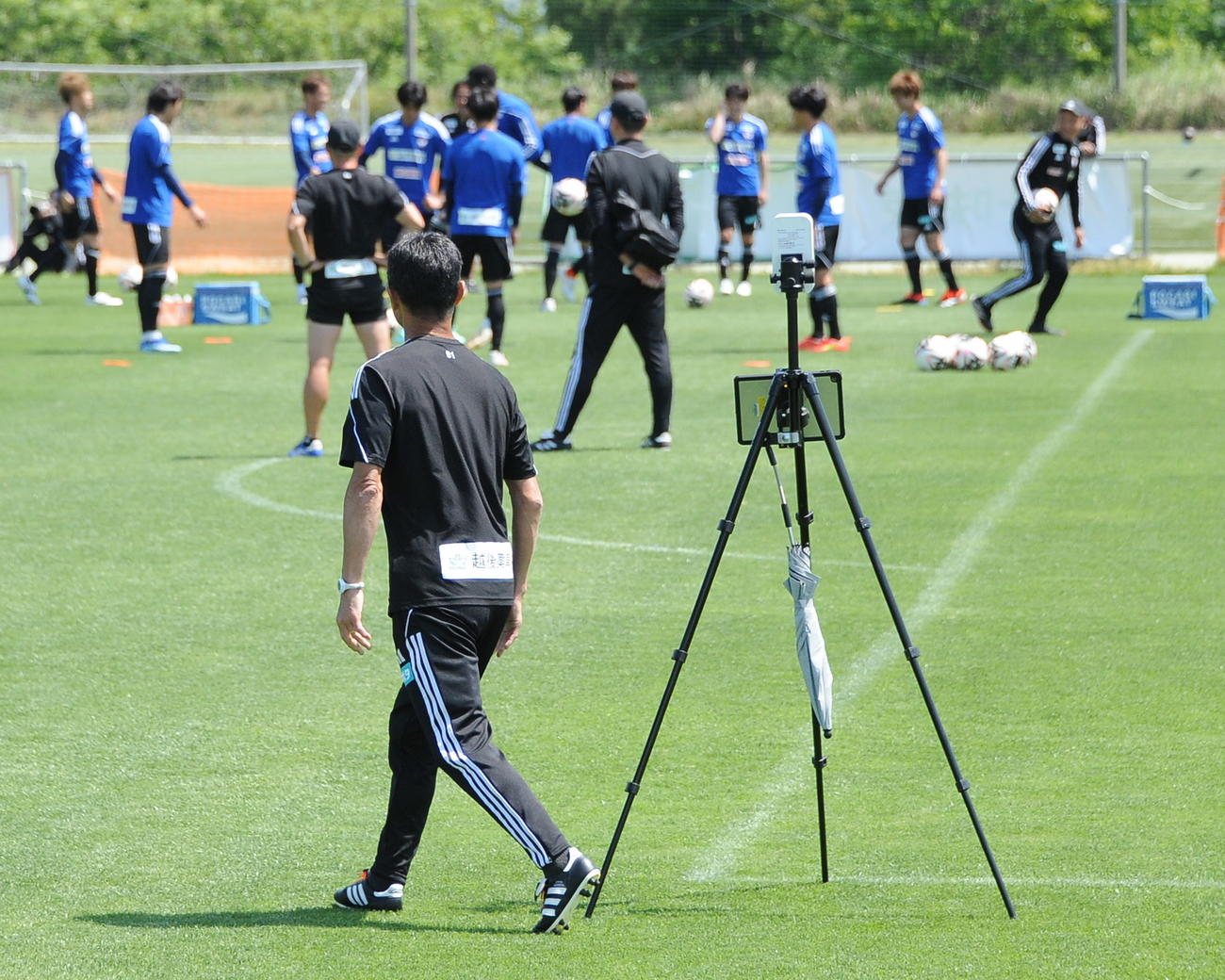 安野フィジカルコーチの目を盗み、選手のGPSデータを拾うアンテナを移動させる松橋監督（手前）