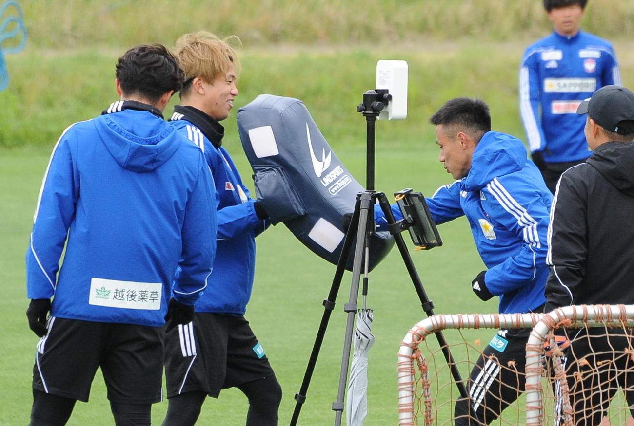 8日の練習後、長谷川元（左から2人目）が構えるヒットバッグに向かってパンチを浴びせる小野