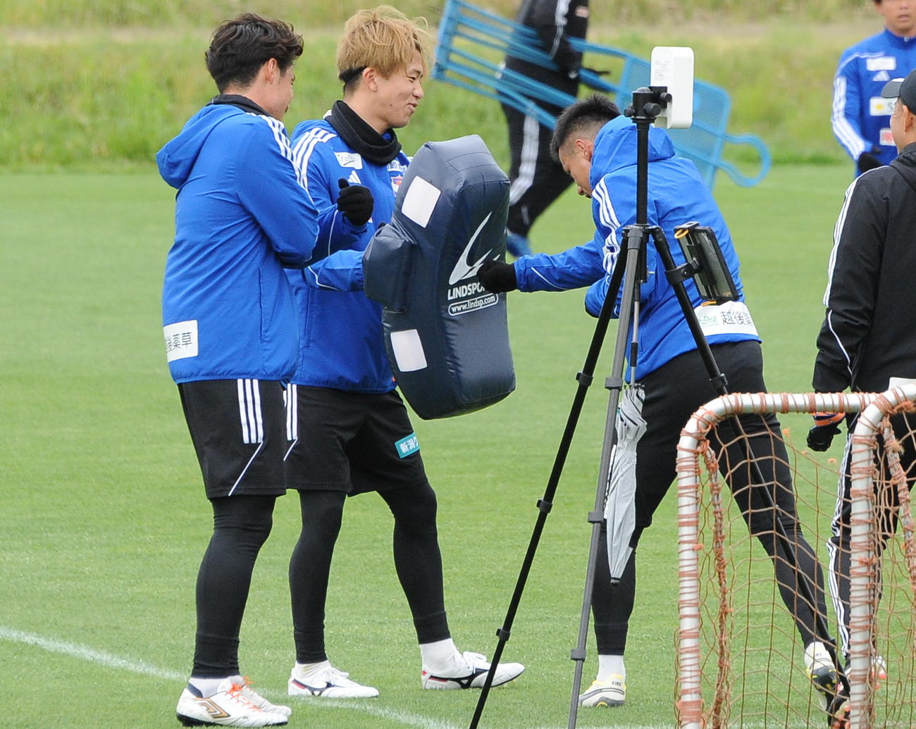 8日の練習後、長谷川元（左から2人目）が構えるヒットバッグに向かってパンチを浴びせる小野