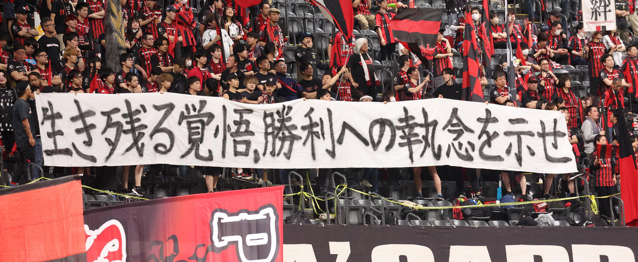 札幌対磐田　試合前、「生き残る覚悟、勝利への執念を示せ」と書かれた横断幕を掲げる札幌サポーター（撮影・佐藤翔太）