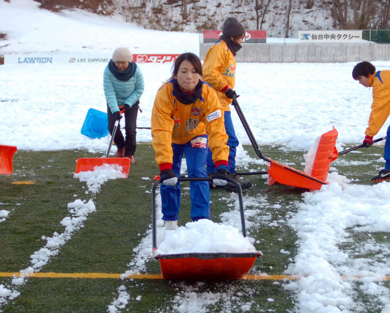 グラウンドの雪かきをする仙台レディースMF鮫島ら（2013年1月29日）