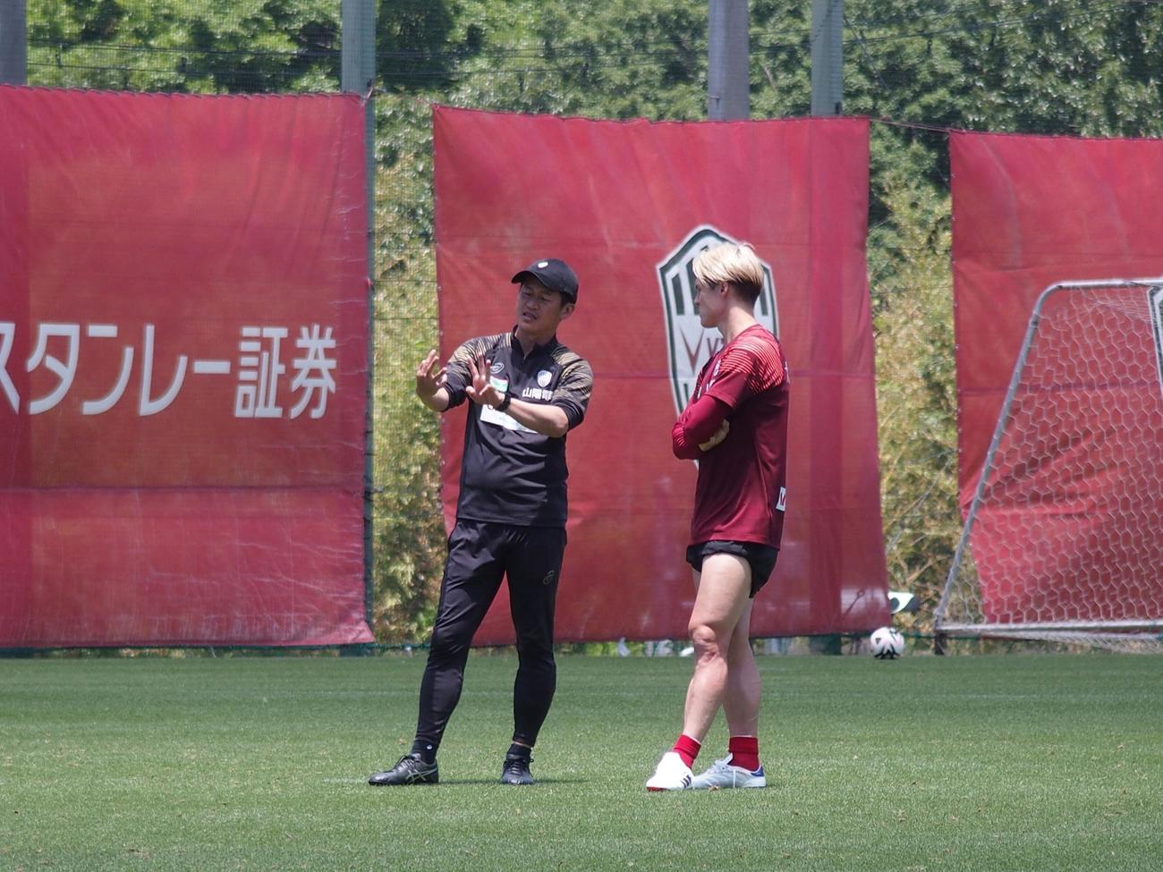 練習後にDF酒井高徳と話し込む神戸の吉田孝行監督（撮影・永田淳）