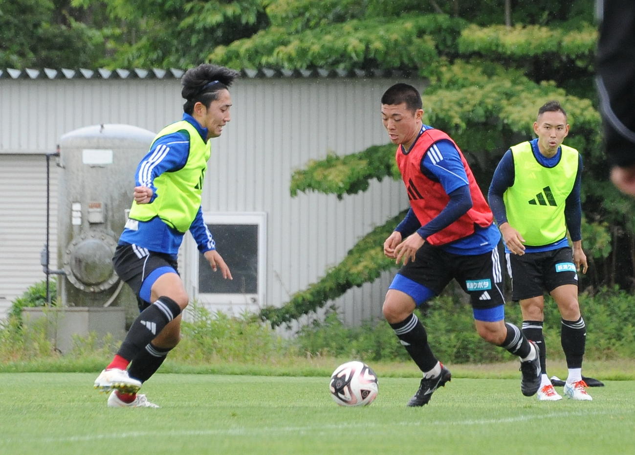 28日、練習でドリブルする新潟小見（中央）