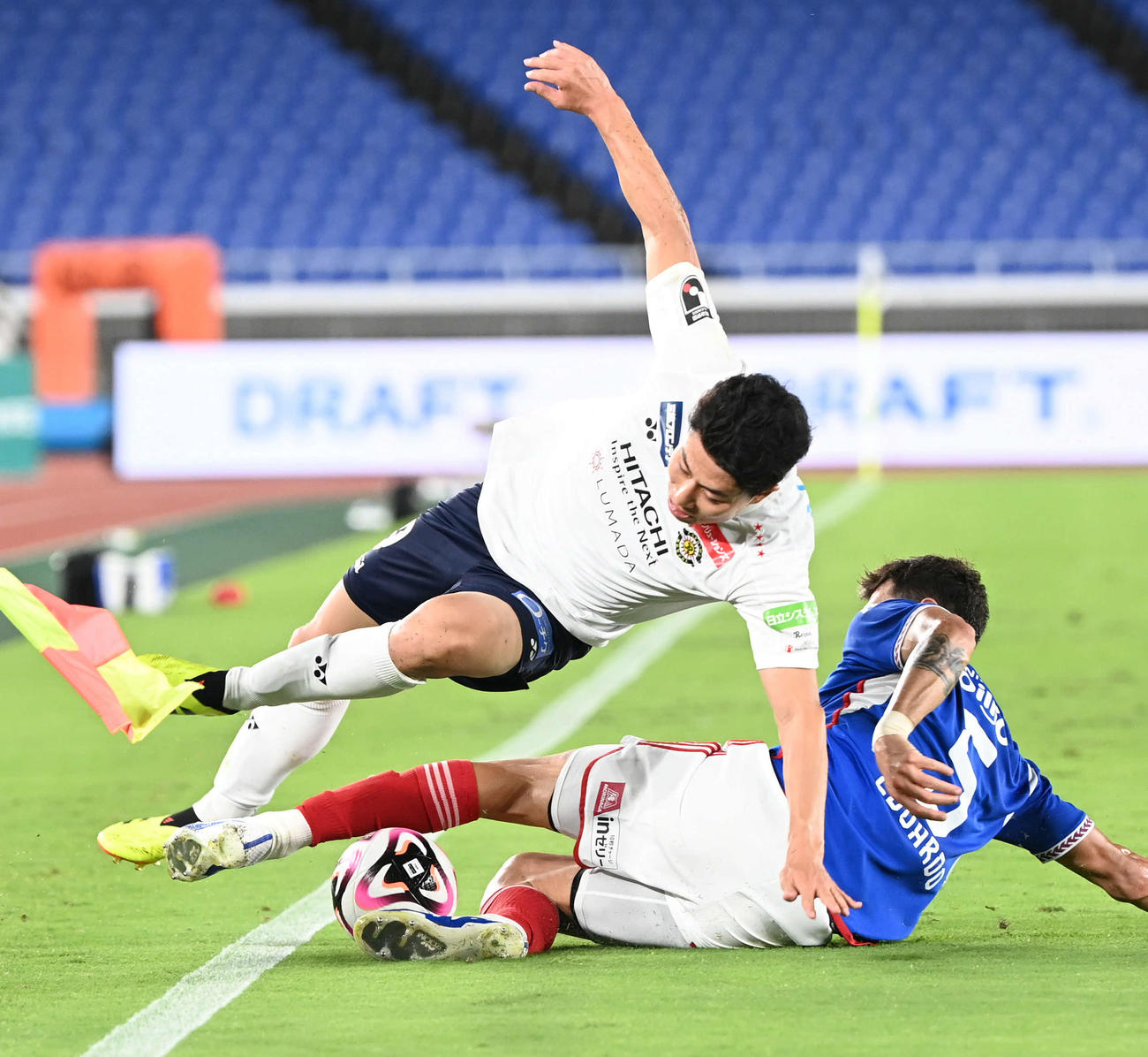 横浜対柏　前半、タックルを受けてサイド突破を止められる柏細谷（上）（撮影・山崎安昭）