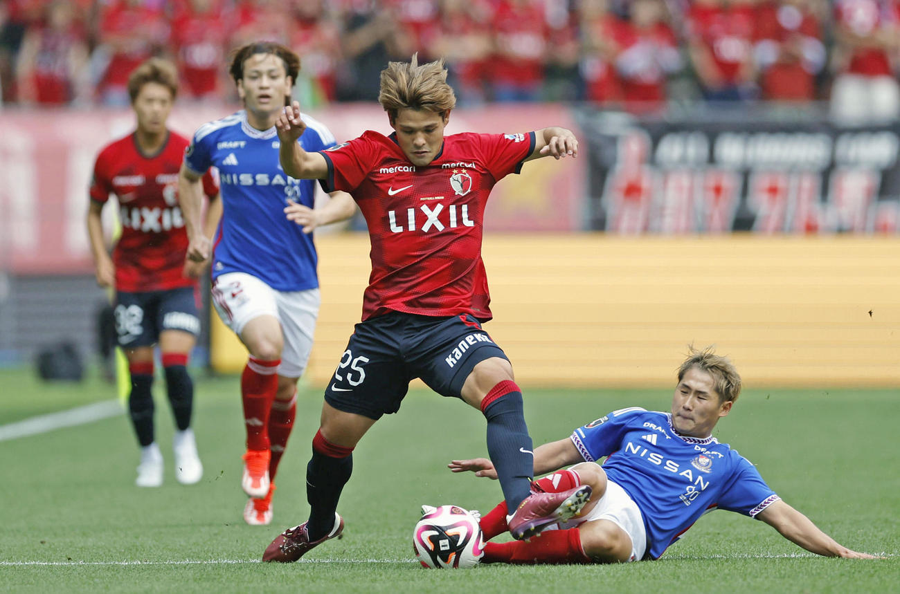 前半、競り合う鹿島・佐野と横浜M・井上（右下）(共同)