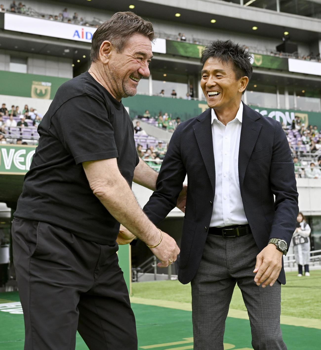 試合前、笑顔であいさつする東京V城福監督（右）と札幌ペトロビッチ監督（共同）