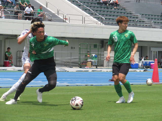 明治大とのトレーニングマッチで球際で激しく競り合う東京VのMF翁長聖。右は見木友哉