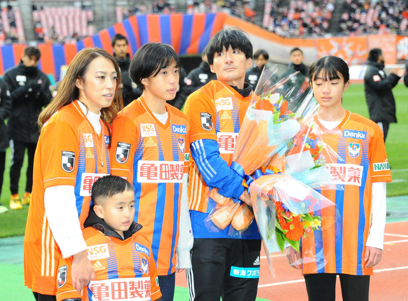 21年12月　今季最終節新潟対町田　今季限りで引退するJ2新潟FW田中達也（39・右から2人目）が試合終了後のセレモニーで家族と撮影に応じる