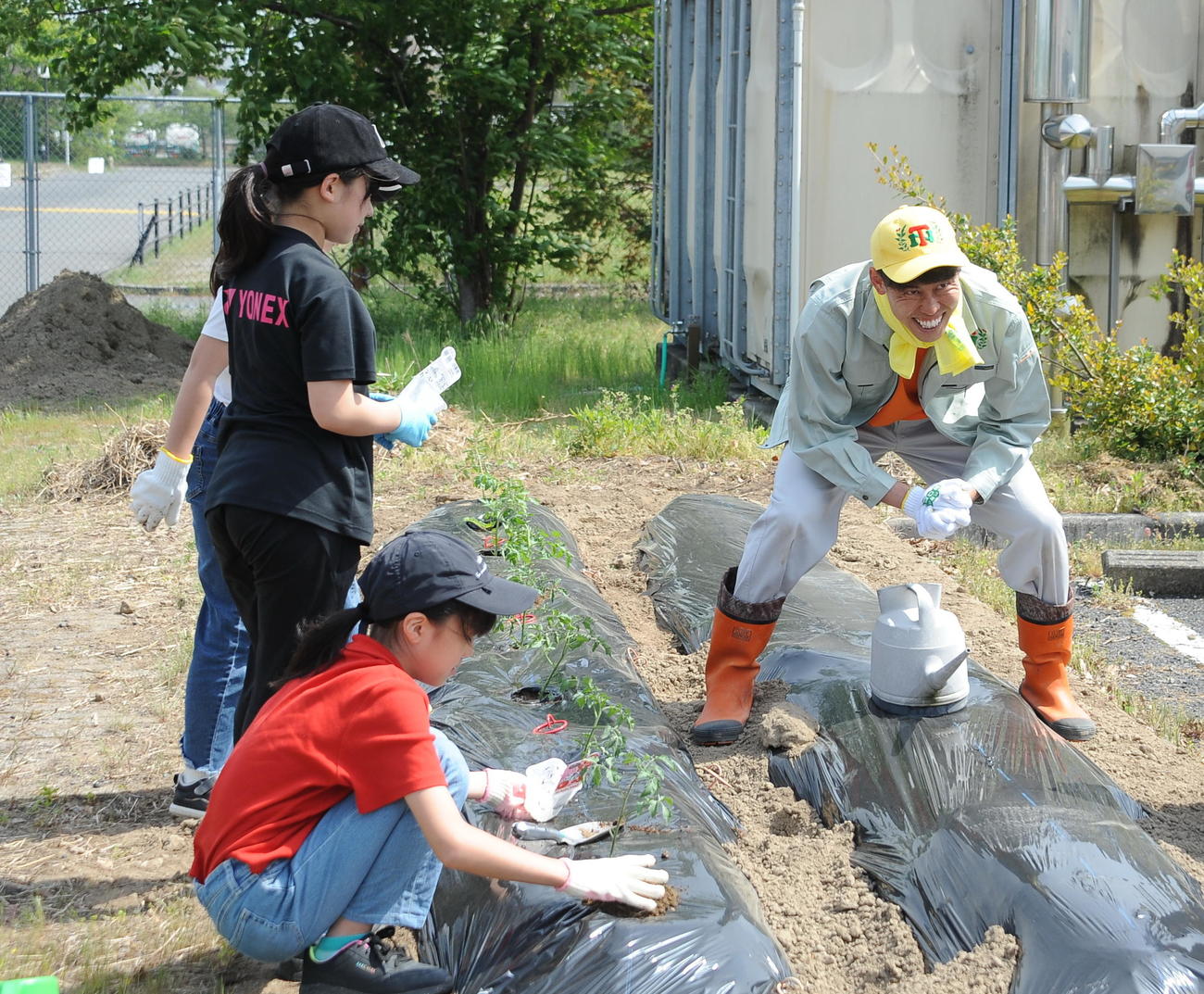 4月29日、クラブハウス前の「谷口農園」で子どもたちと野菜の苗を植える谷口（右）