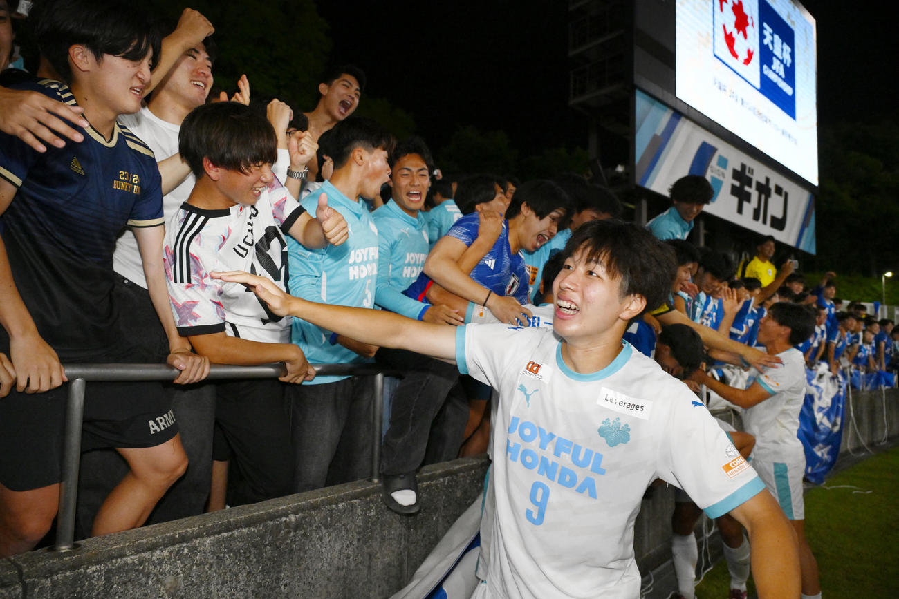 PK戦の末、町田に勝利し笑顔でタッチを交わす筑波大・内野（右）（共同）