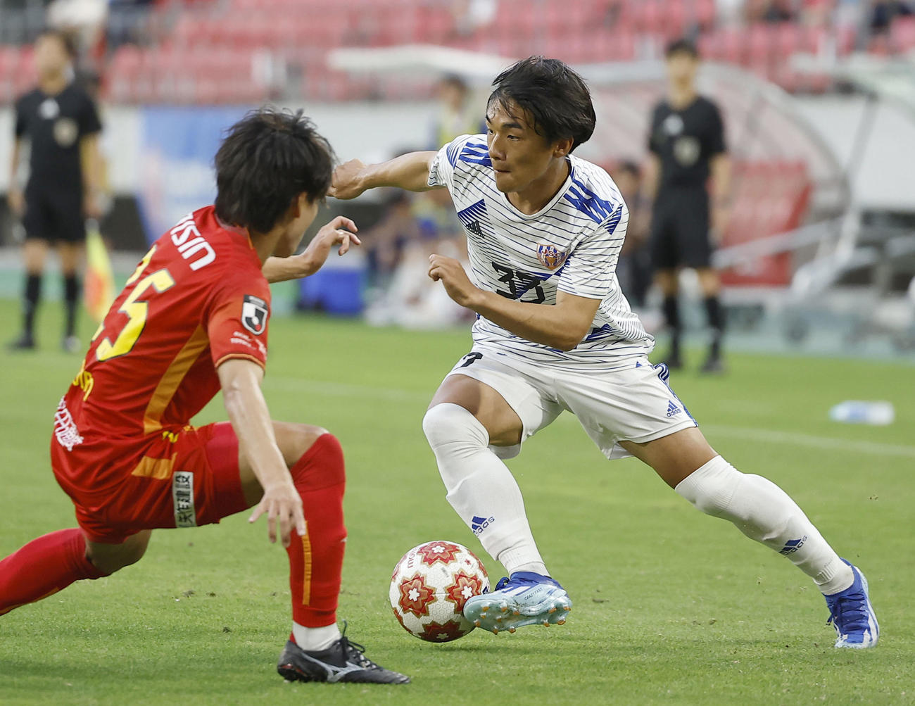 名古屋対JAPANカレッジ　前半、競り合うJAPANカレッジ・本田（右）（共同）