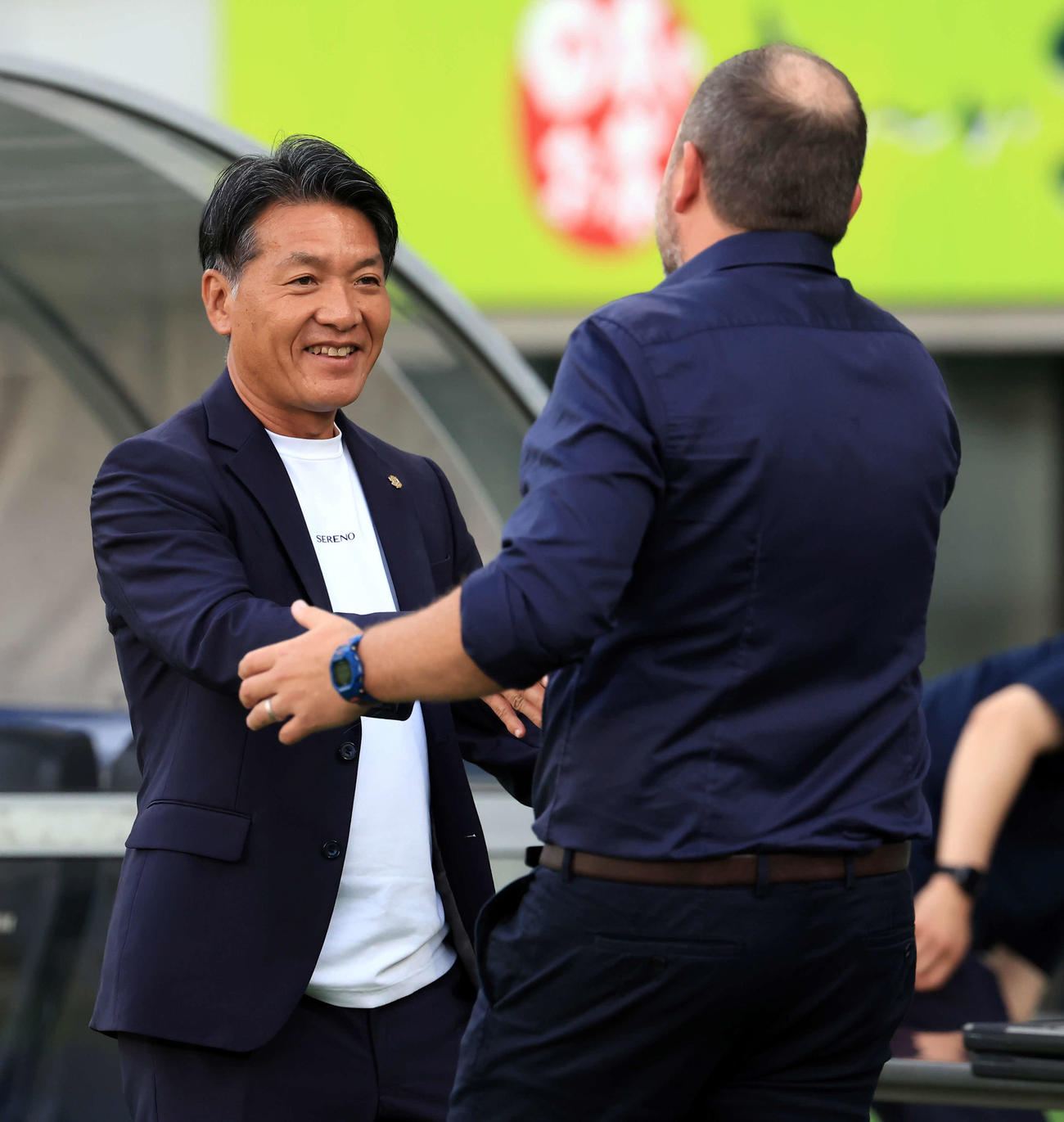 東京対磐田　試合前、東京クラモフスキー監督（右）と笑顔で握手する磐田横内監督（撮影・浅見桂子）