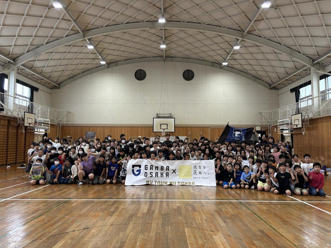 茨木市内の小学校で記念撮影するガンバ大阪の選手・スタッフ（撮影・永田淳）