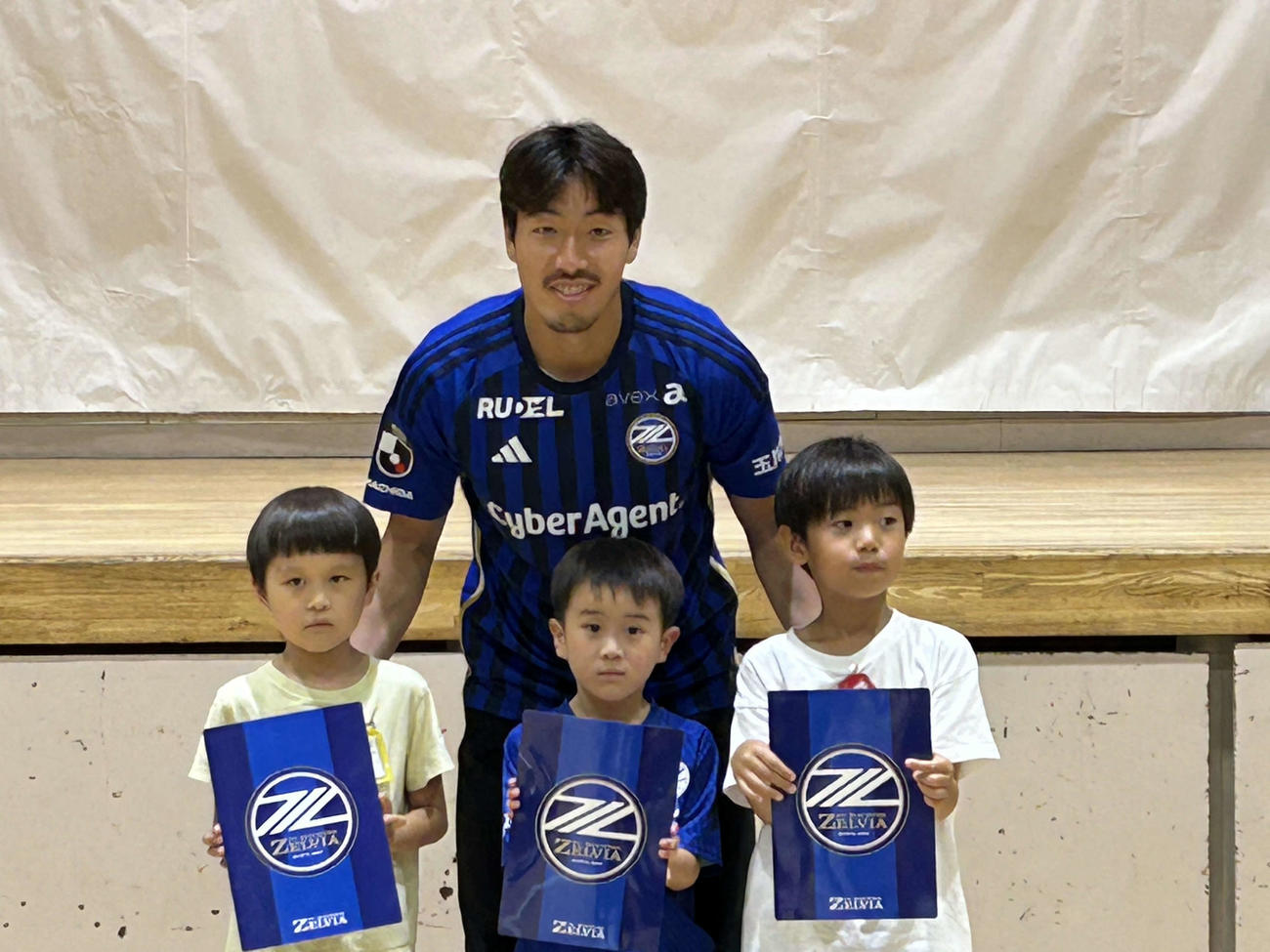 下敷きを手渡し記念撮影に応じる町田DF昌子源