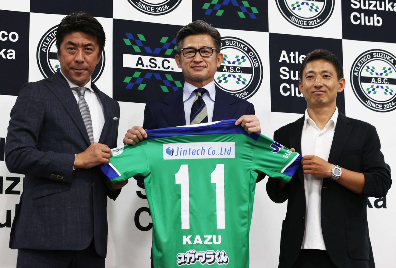 アトレチコ鈴鹿への期限付き移籍を発表したカズはユニホームを手にする。左は斉藤社長。右は朴監督。（撮影・水谷安孝）