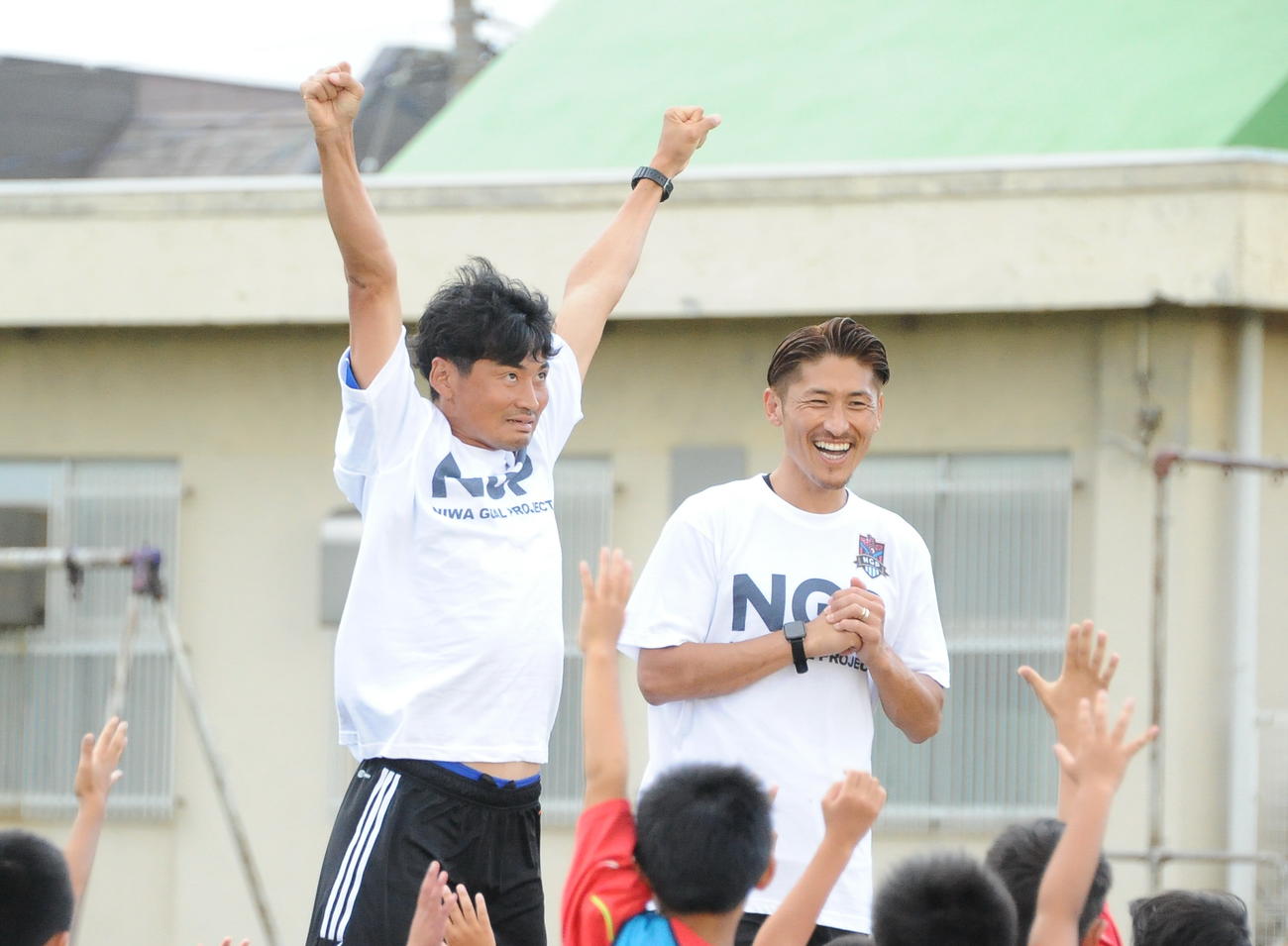 サッカー教室開始前にギャグを飛ばす千葉（左）と、笑顔の丹羽