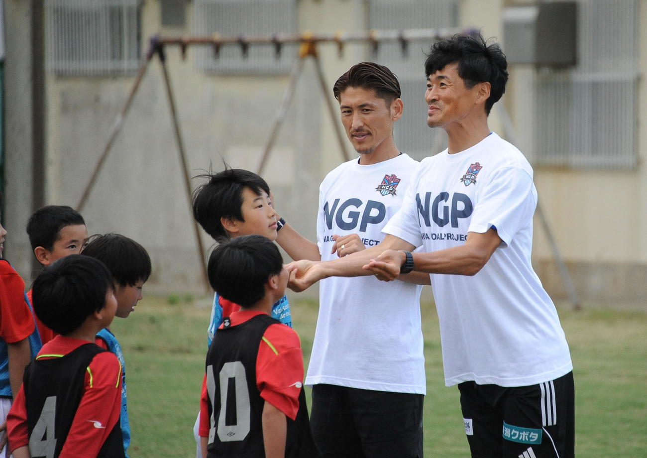 サッカー教室開始前にギャグを飛ばす千葉（右）と、見つめる丹羽（中央）