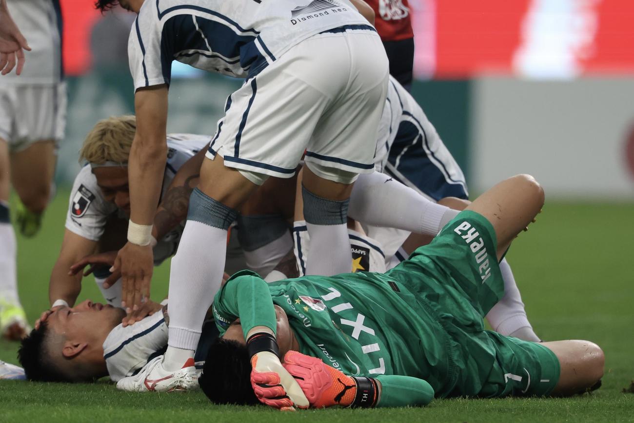 第22節　鹿島対札幌　前半、接触し負傷する鹿島GK早川（手前）と札幌小林＝2024年7月6日　