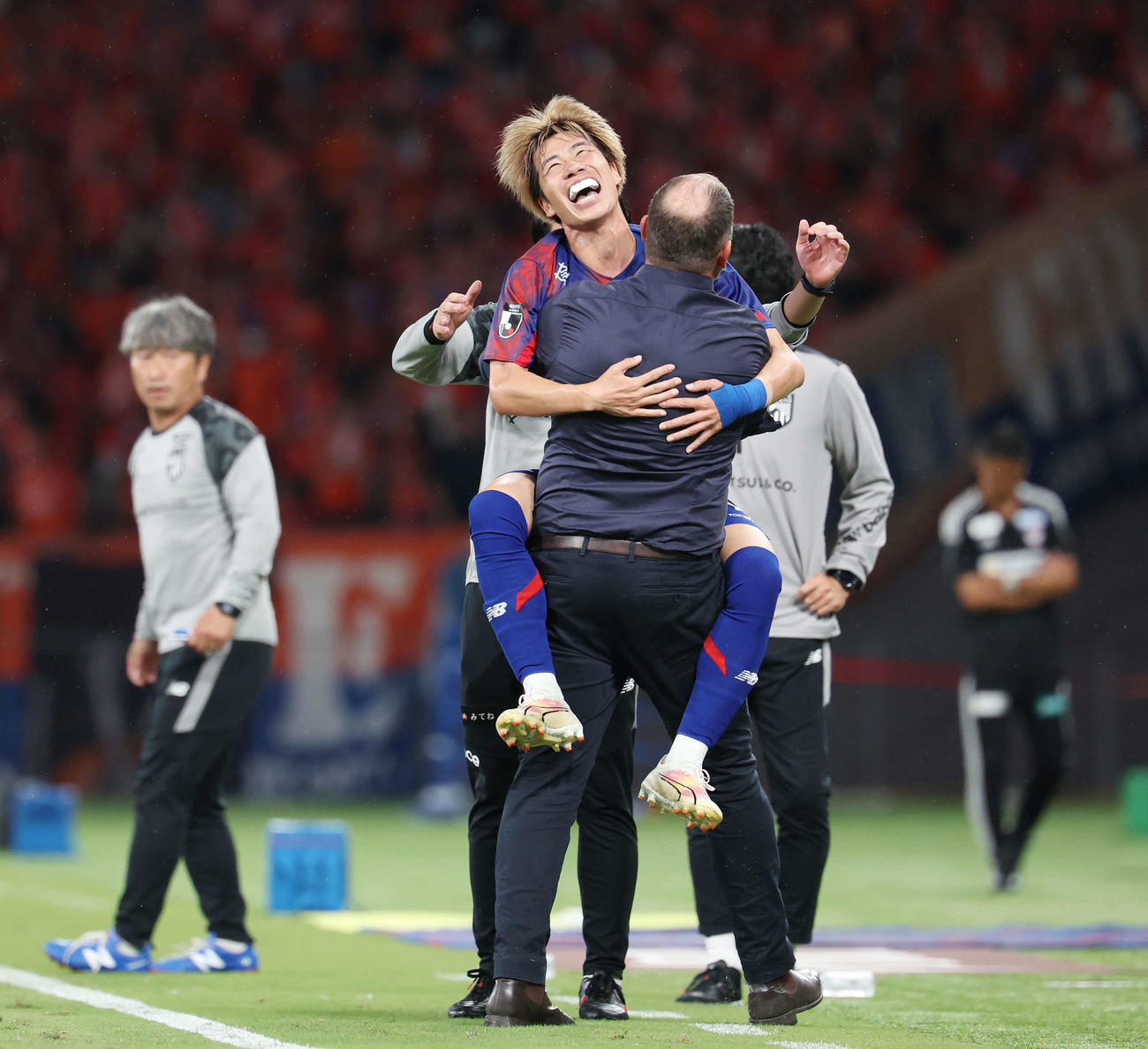 東京対新潟　後半、ゴールを決め東京クラモフスキー監督（手前）に抱きつく野沢零（撮影・宮地輝）