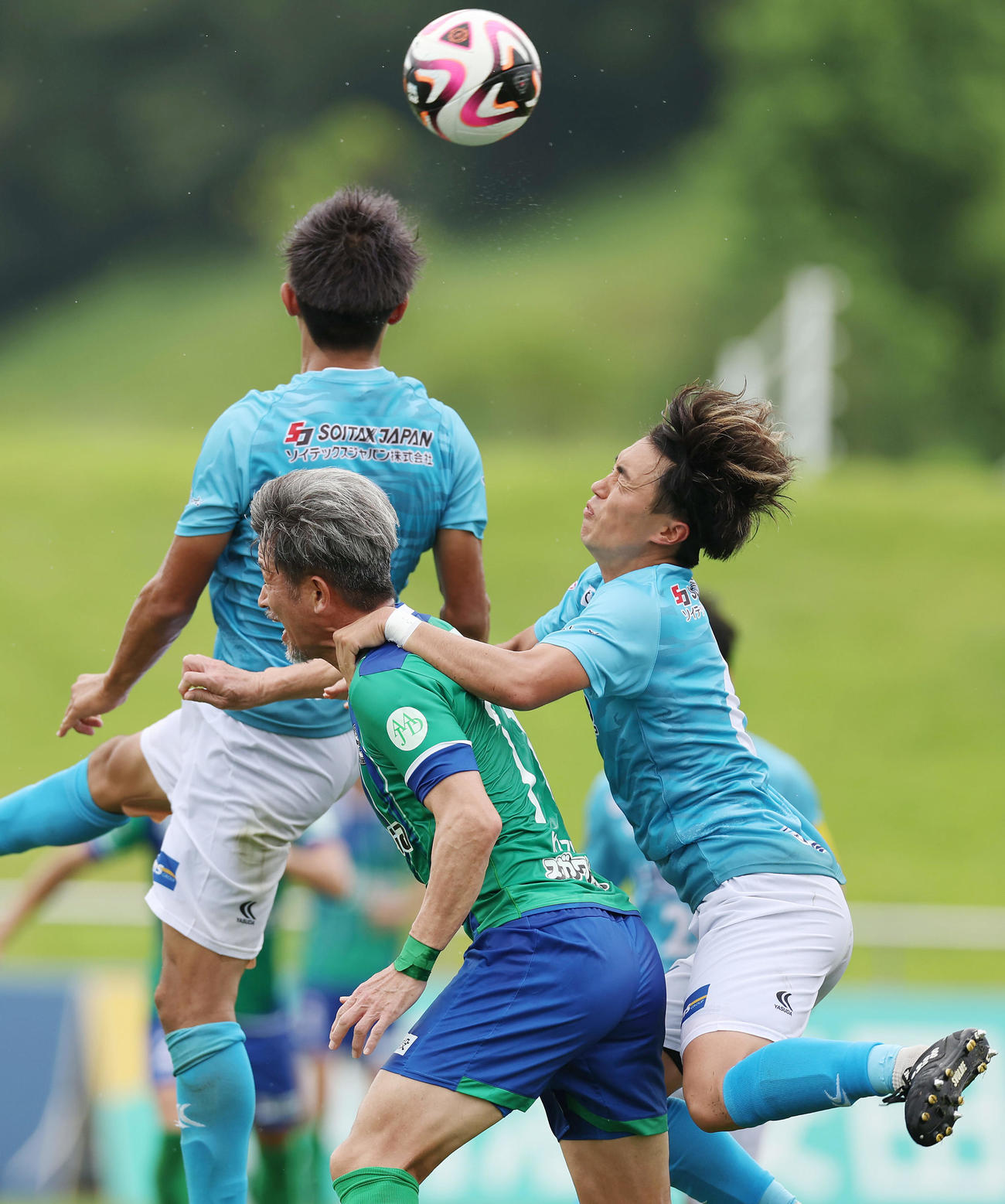鈴鹿対V大分　後半、ゴール前で競り合う鈴鹿カズ（中央）（撮影・前田充）