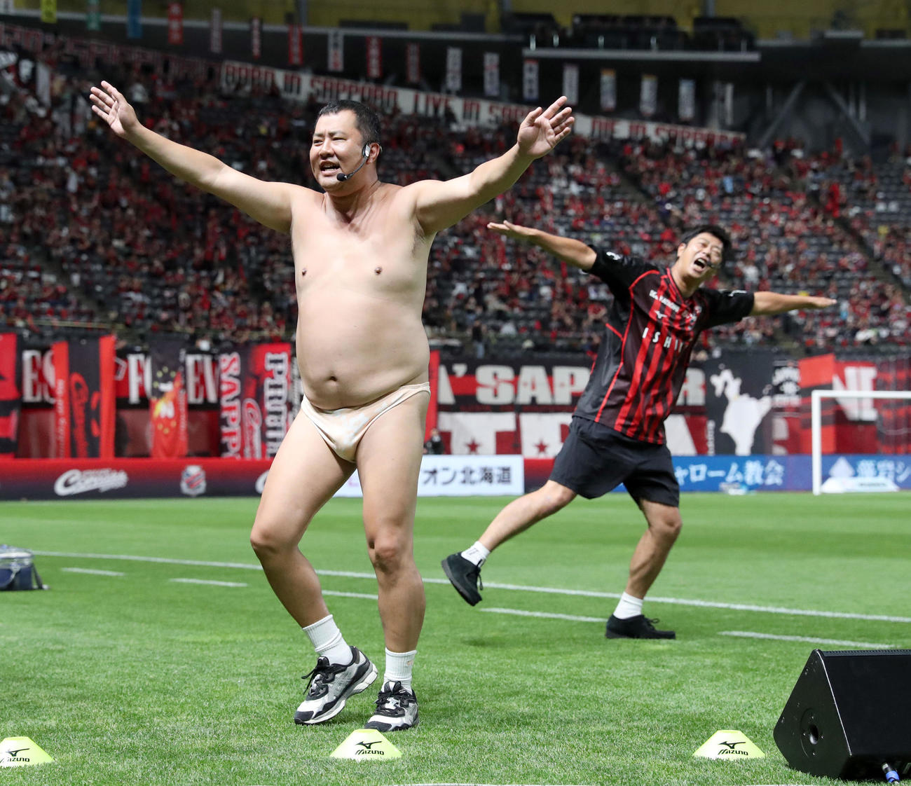 札幌対福岡　試合前、ピッチに登場するとにかく明るい安村（左）とパンサー尾形（撮影・佐藤翔太）