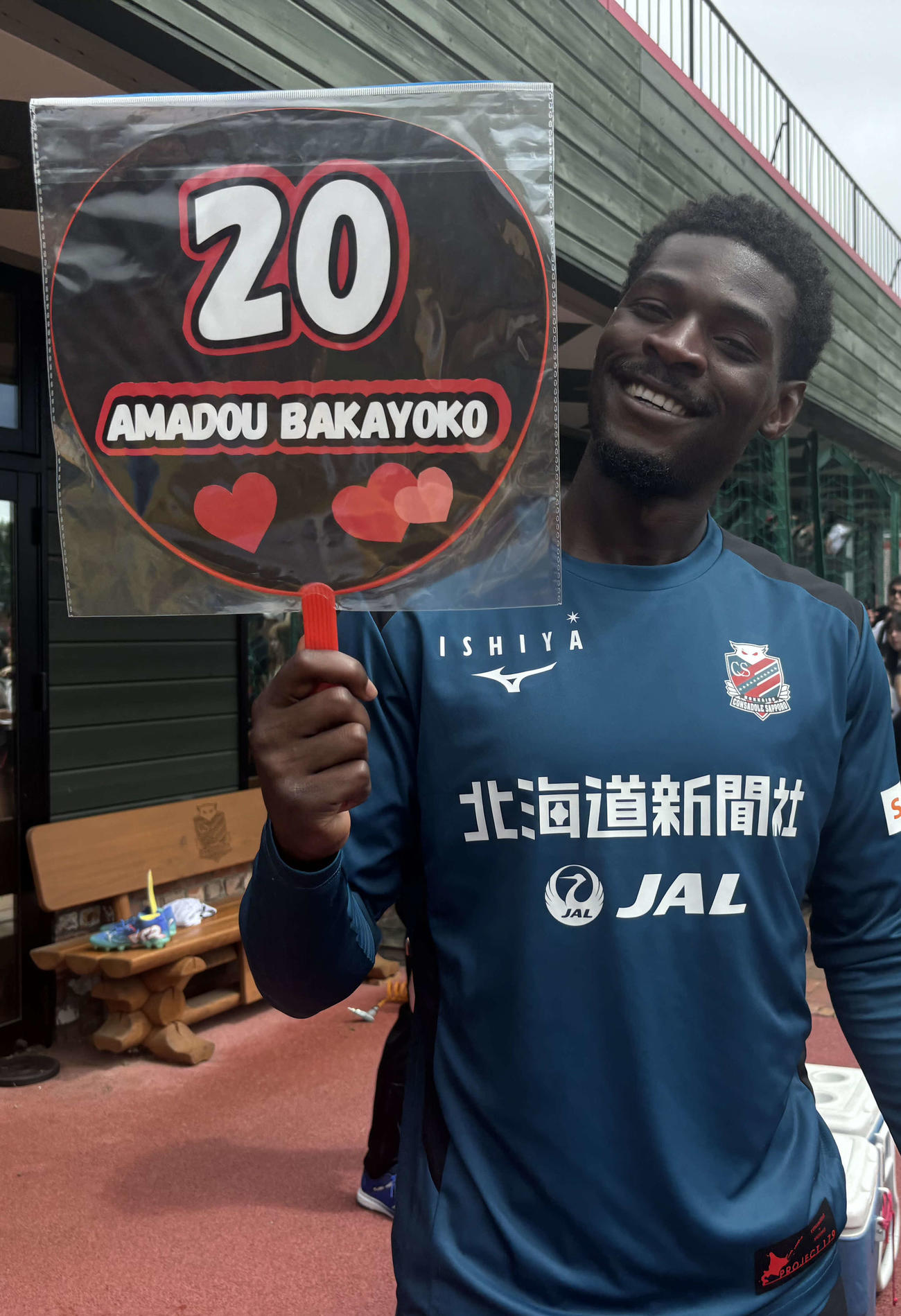 鳥栖戦前日練習後、ファンからプレゼントされたうちわを手に笑顔の札幌アマドゥ・バカヨコ（撮影・保坂果那）