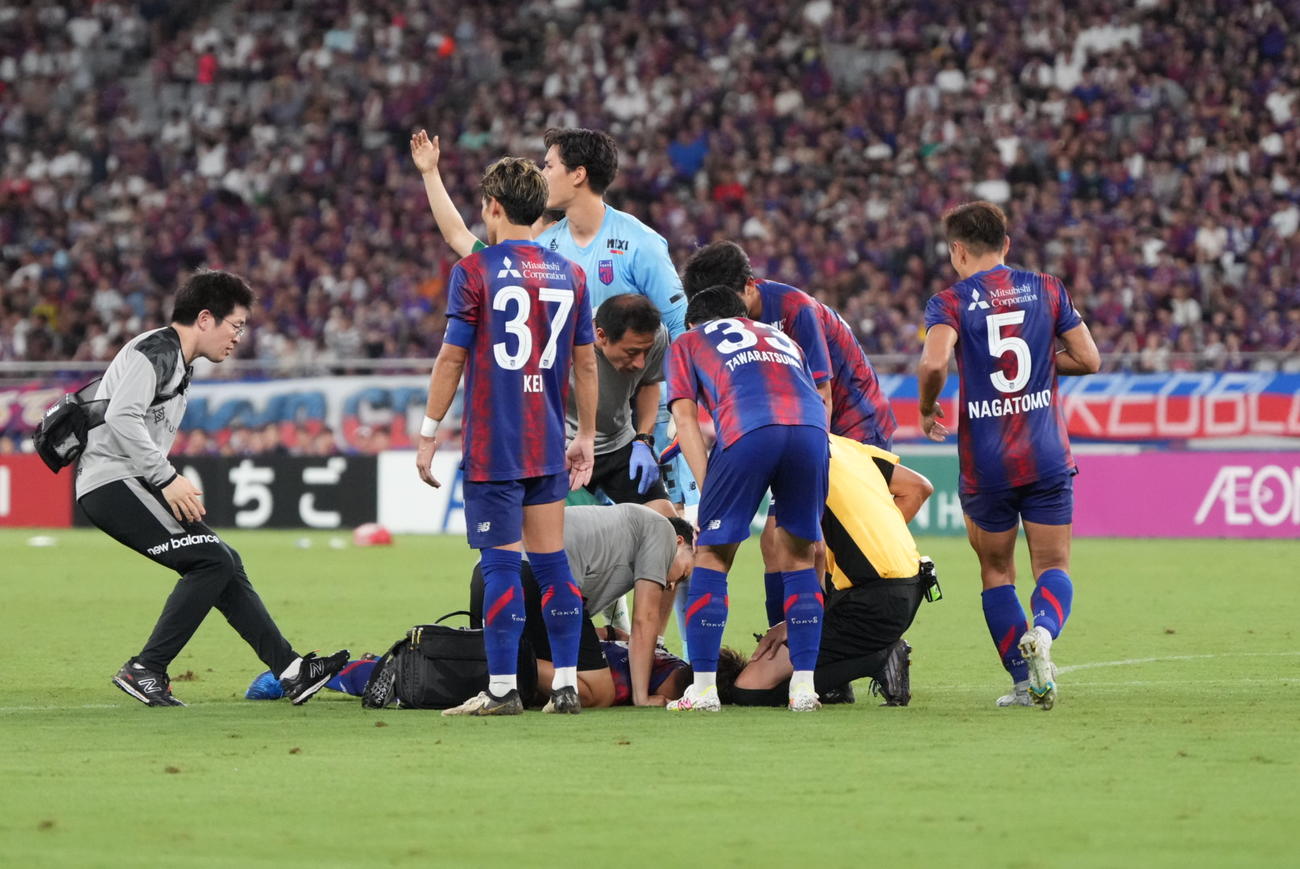 東京対東京V　後半、東京森重がピッチに倒れ込み心配したイレブンが駆け寄る（撮影・小沢裕）