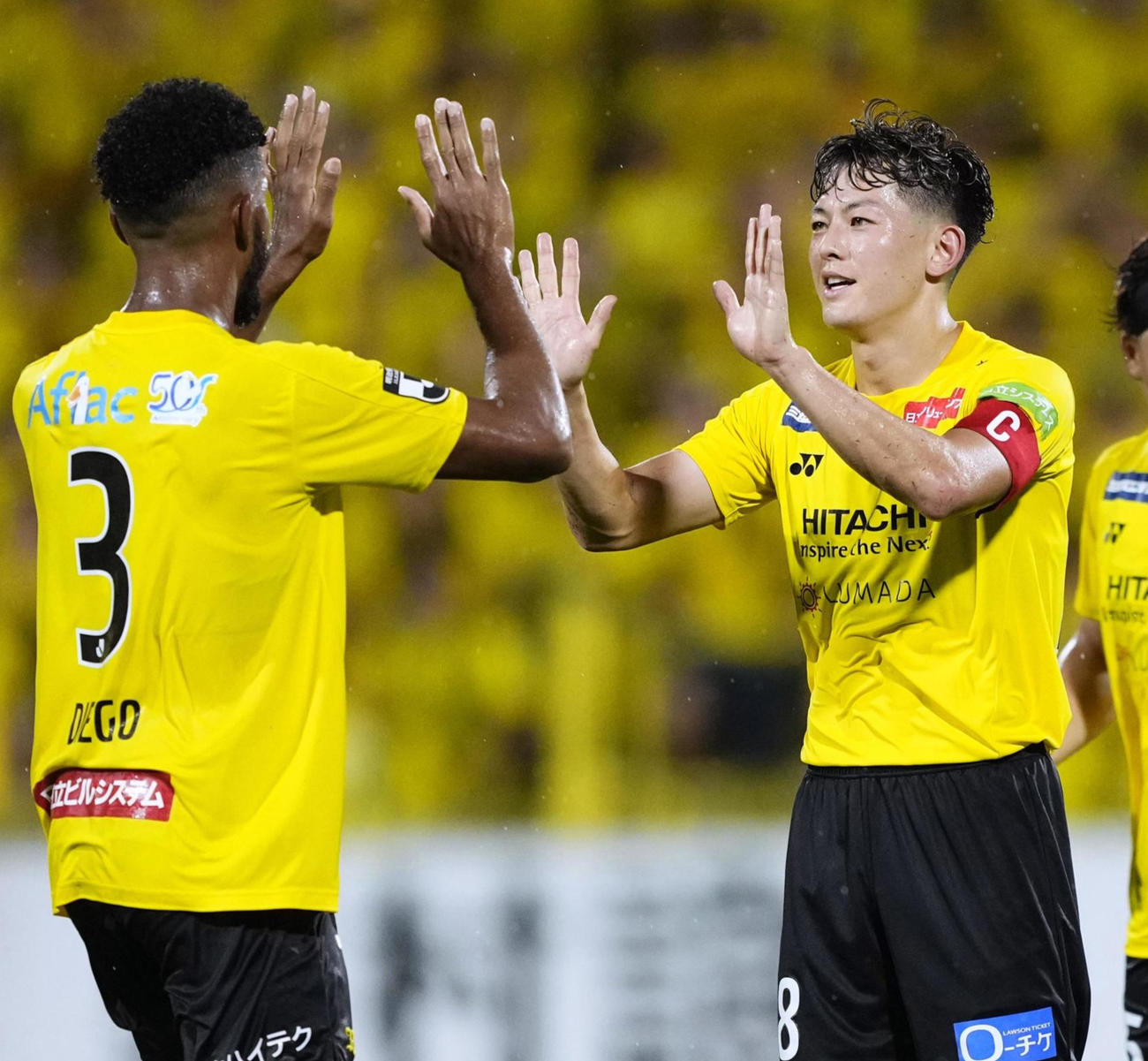 前半終了間際、チーム2点目のゴールを決めタッチを交わす柏戸嶋（右）（共同）