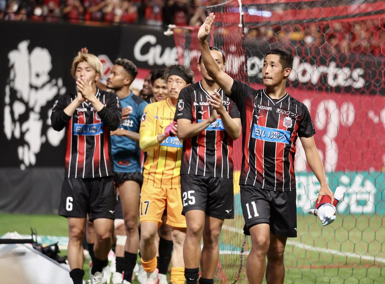札幌対川崎F　試合終了後、サポーターに向かって手を振りながら引き揚げる札幌青木（右手前）らイレブンたち（撮影・佐藤翔太）