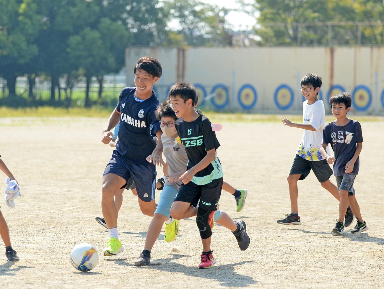 母校の校庭で児童らとプレーする磐田鈴木（左端）（撮影・神谷亮磨）