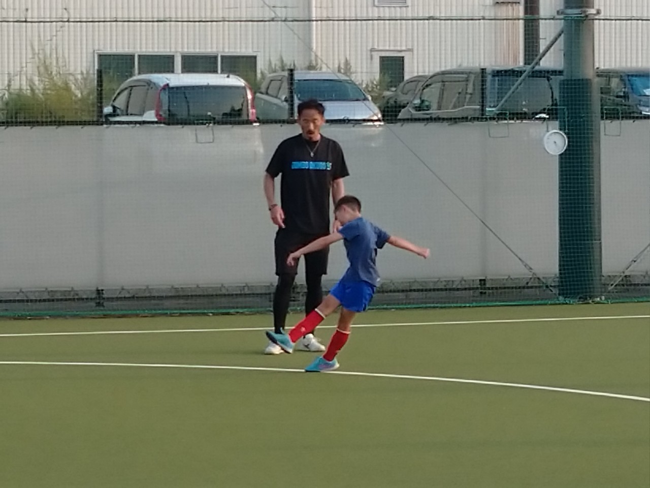 自身が立ち上げたスクールで小学生にシュートのフォームを指導するFW大久保哲哉