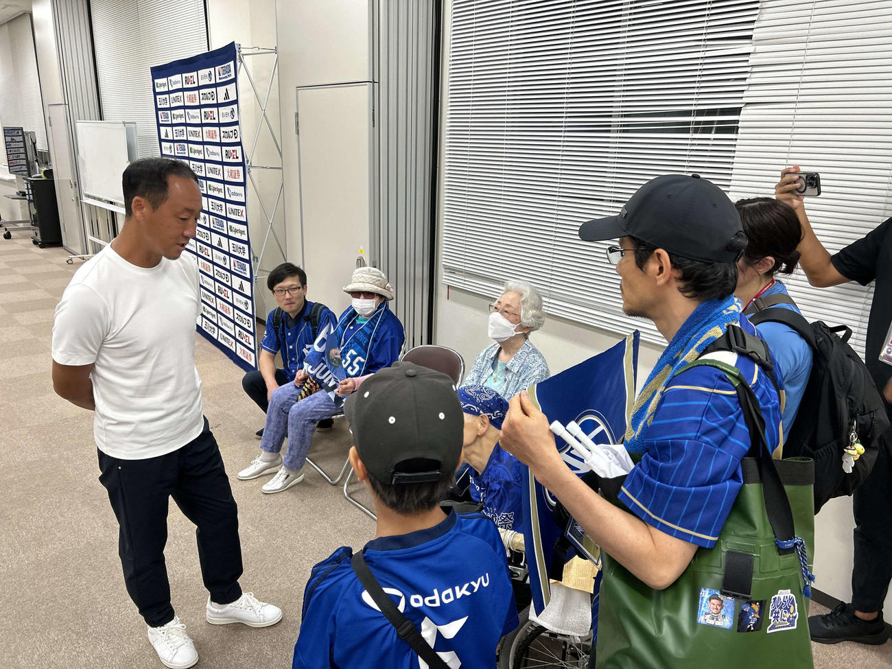 試合会場を訪れた地元の高齢者サポーターと談笑する町田の黒田監督
