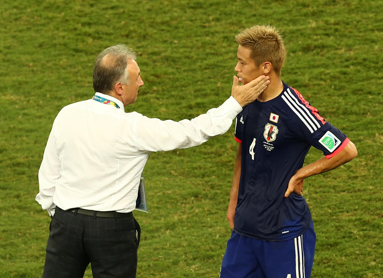 14年6月、W杯ブラジル大会1次リーグのコロンビア戦で、1次リーグ敗退が決まり、本田（右）はザッケローニ監督からねぎらわれる