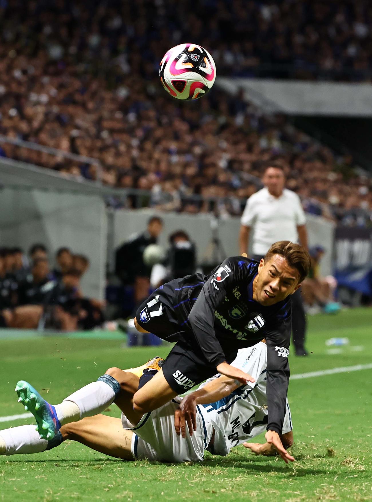 G大阪対札幌　前半、札幌パク・ミンギュ（右）に倒されるG大阪山下（撮影・上田博志）