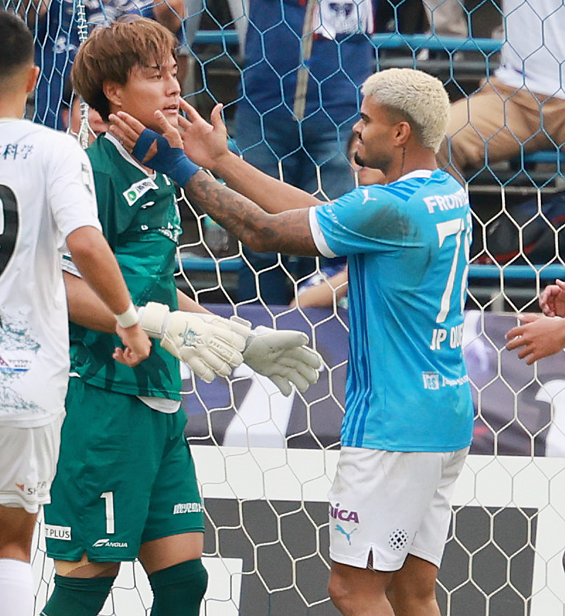 横浜FC対鹿児島　後半、自らのシュートを防いだ鹿児島GK泉森涼太（左）をたたえる横浜FCジョアン・パウロ（撮影・野上伸悟）