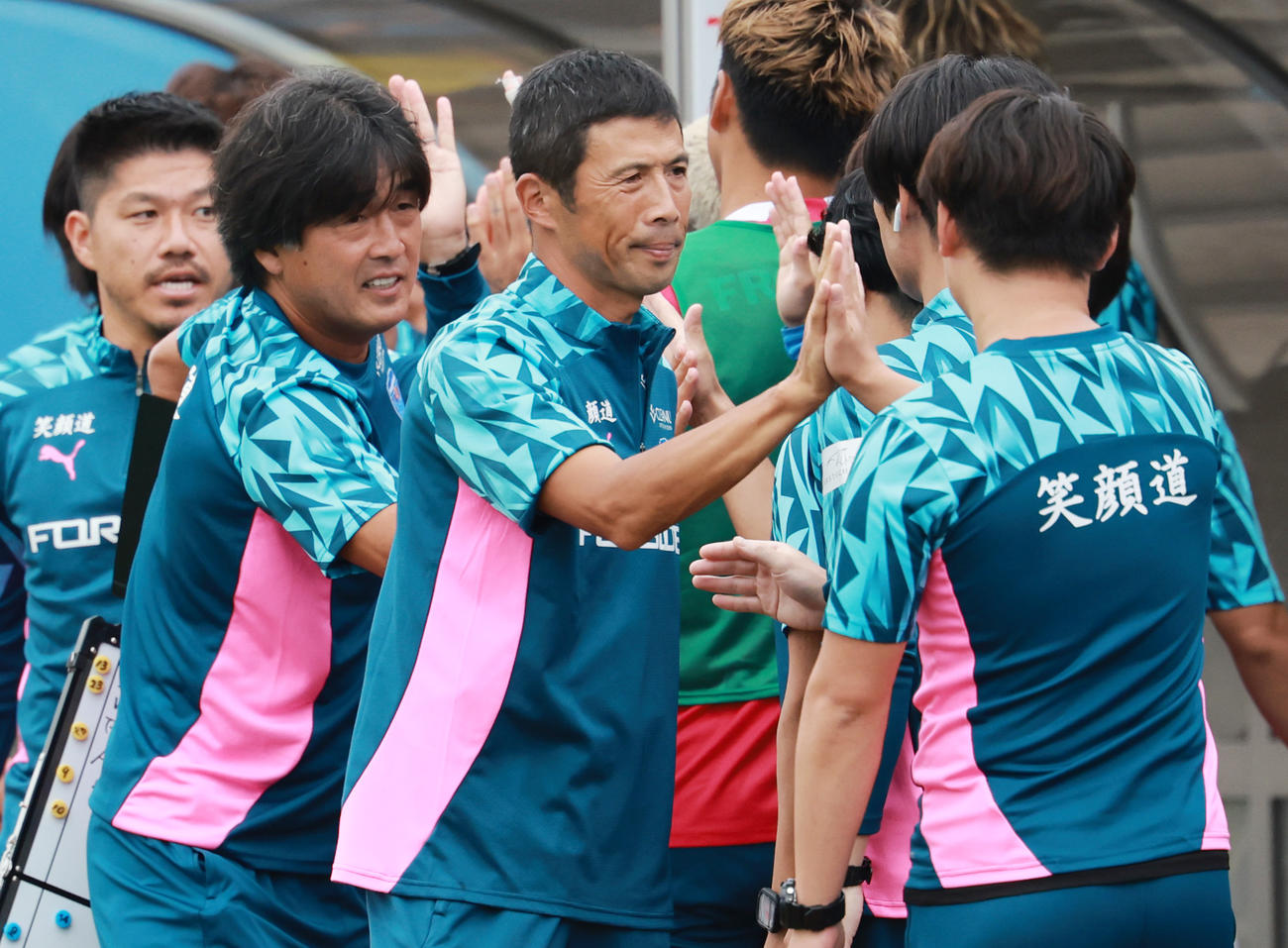 横浜FC対鹿児島　スタッフと勝利を喜びあう横浜FC四方田監督（撮影・野上伸悟）