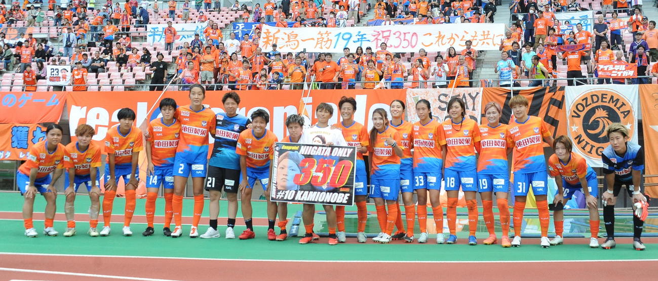 前節でリーグ通算350試合出場を達成し、ホームのファンをバックに記念撮影に応じる新潟L上尾野辺（中央）（撮影・小林忠）