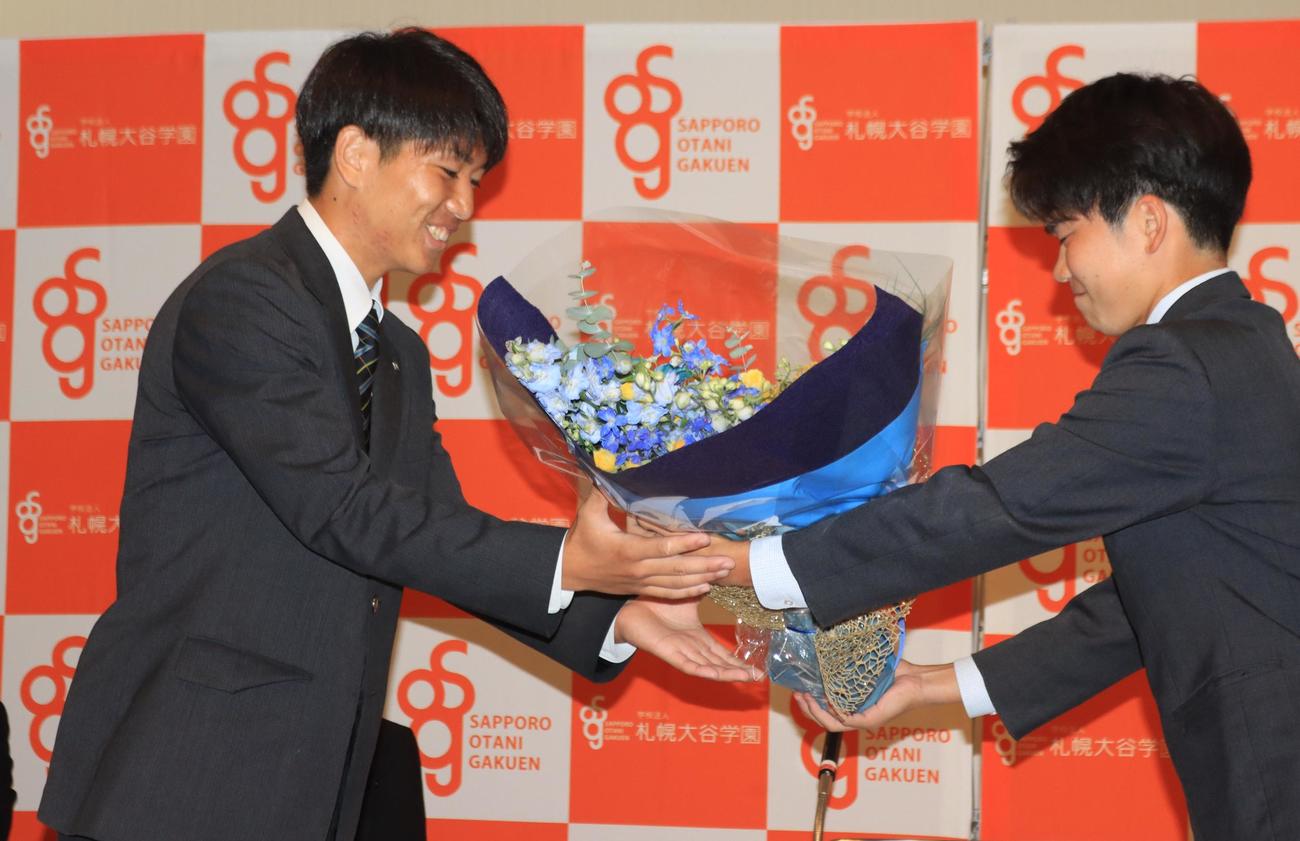 J3今治への来季加入が内定した札幌大谷高の笹（左）はチームメートから花束を受け取る（撮影・保坂果那）