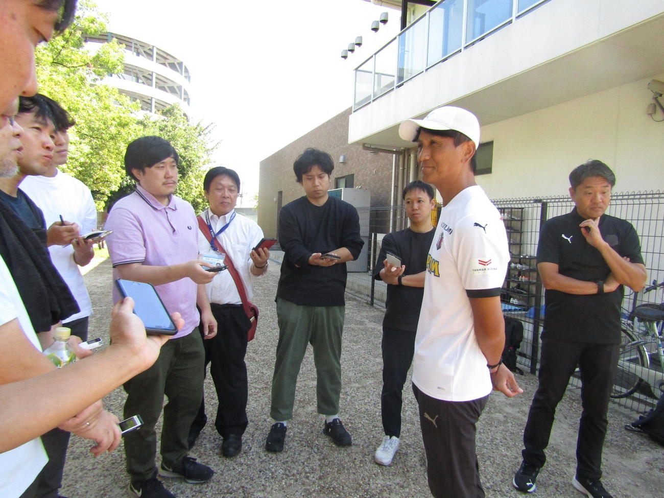 多くの報道陣に囲まれて取材に応じるC大阪小菊監督（中央手前）
