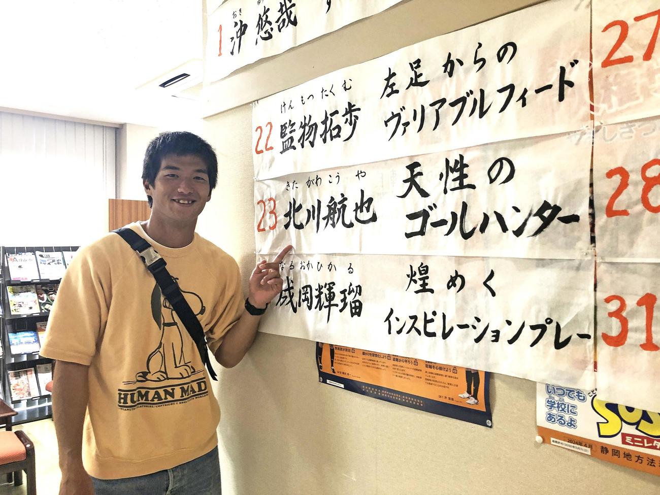 母校の生徒が書いた習字を指さして笑顔を見せる清水北川（エスパルス提供）