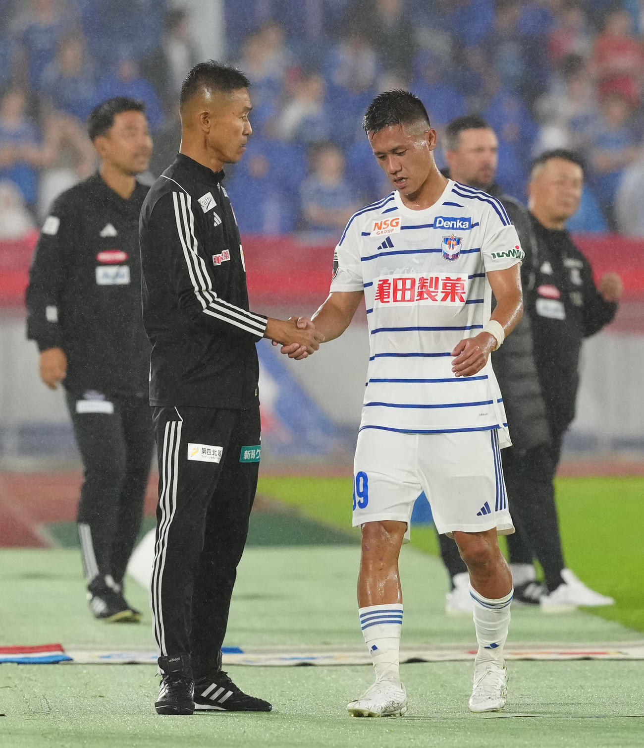 横浜対新潟　前半途中で交代し新潟松橋監督（左）と握手を交わす小野（撮影・江口和貴）