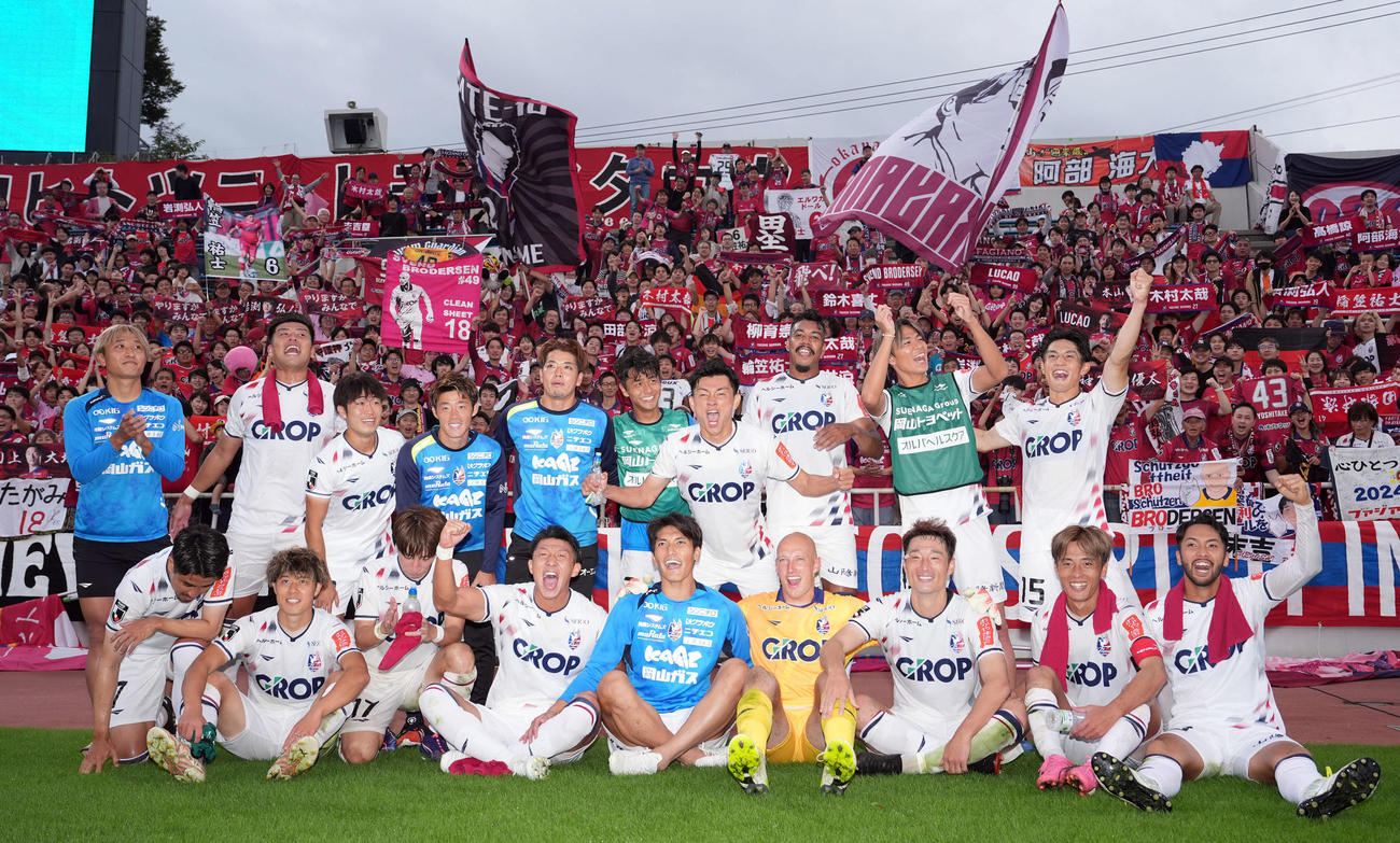 横浜FC対岡山　横浜FCに勝利しサポーターの背に記念撮影に納まる岡山イレブン（撮影・たえ見朱実）