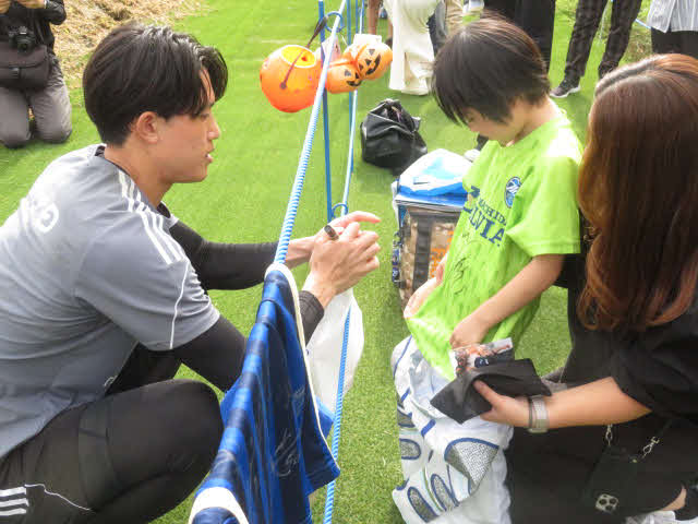 ハロウィーン交流でファンの男児にサインする町田GK谷