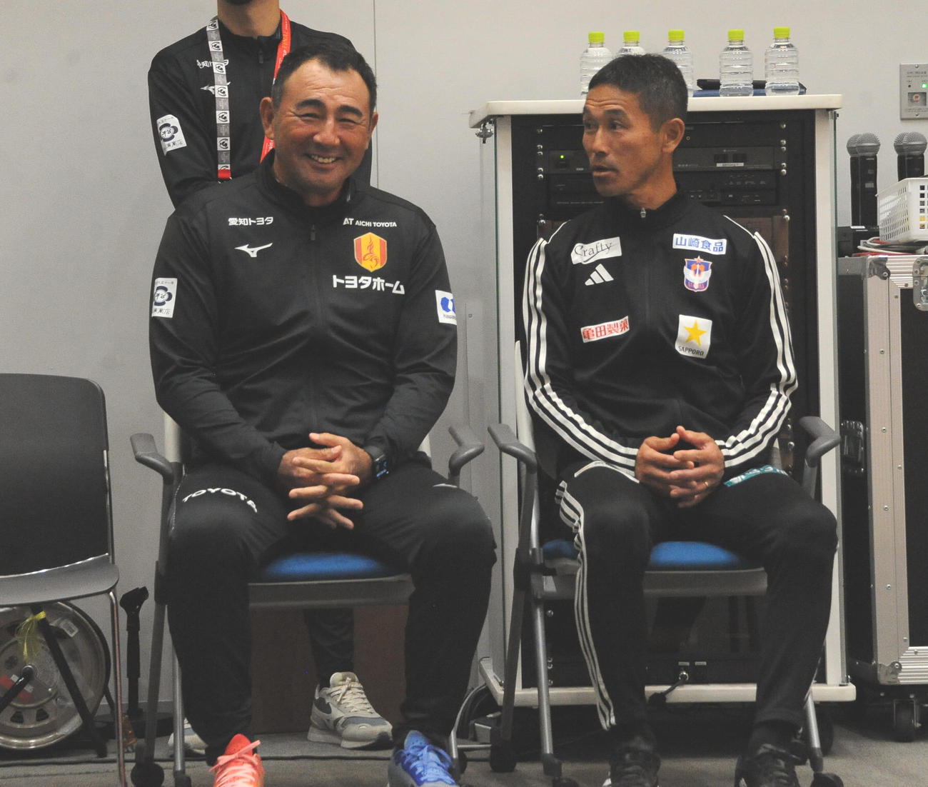 ルヴァン杯決勝に向けた合同記者会見で選手がフォトセッションをしている間、笑顔で談笑する名古屋長谷川監督（左）と新潟松橋監督（撮影・小林忠）