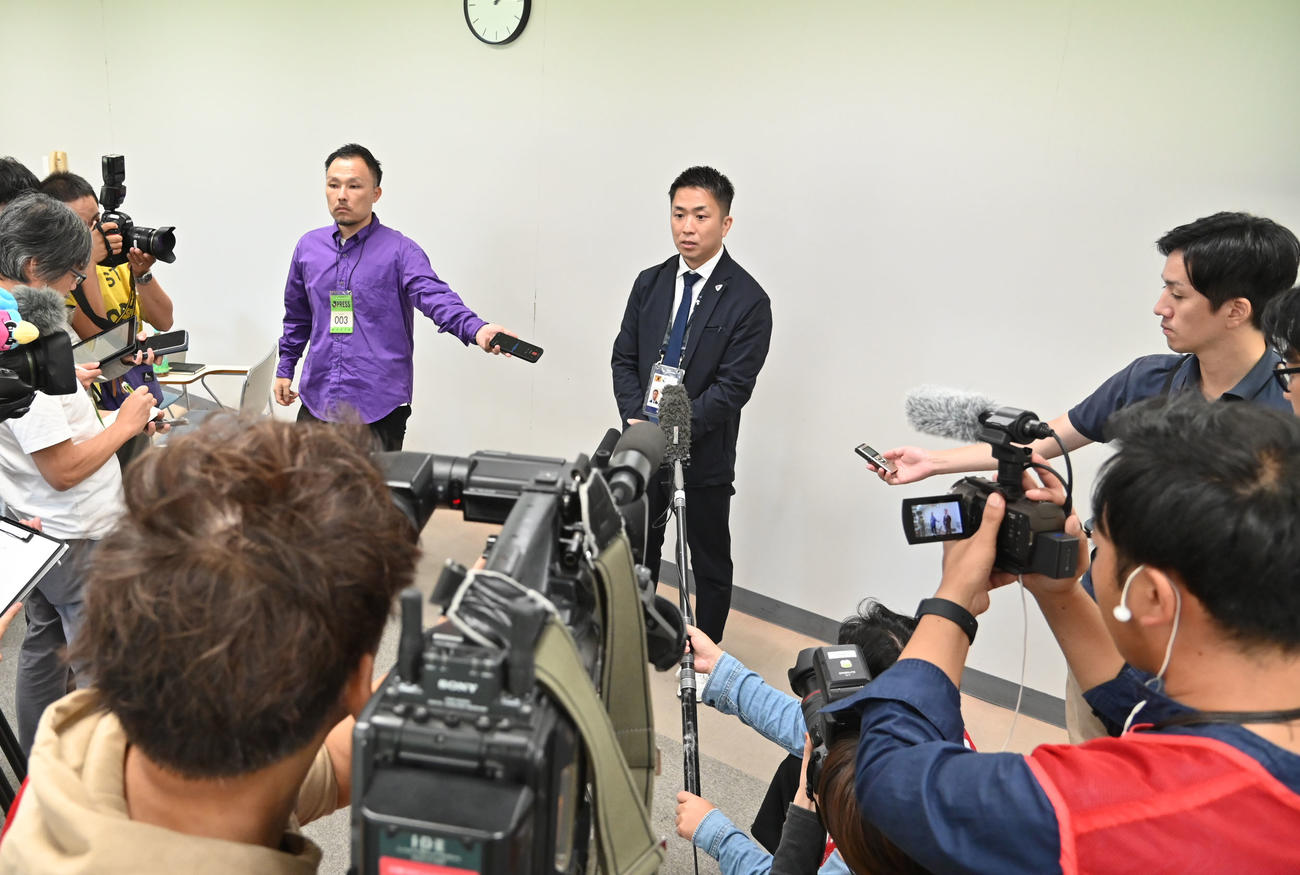 報道陣の囲み取材に応じる株式会社サガン・ドリームス代表取締役の小柳智之（中央）（撮影・林敢治）