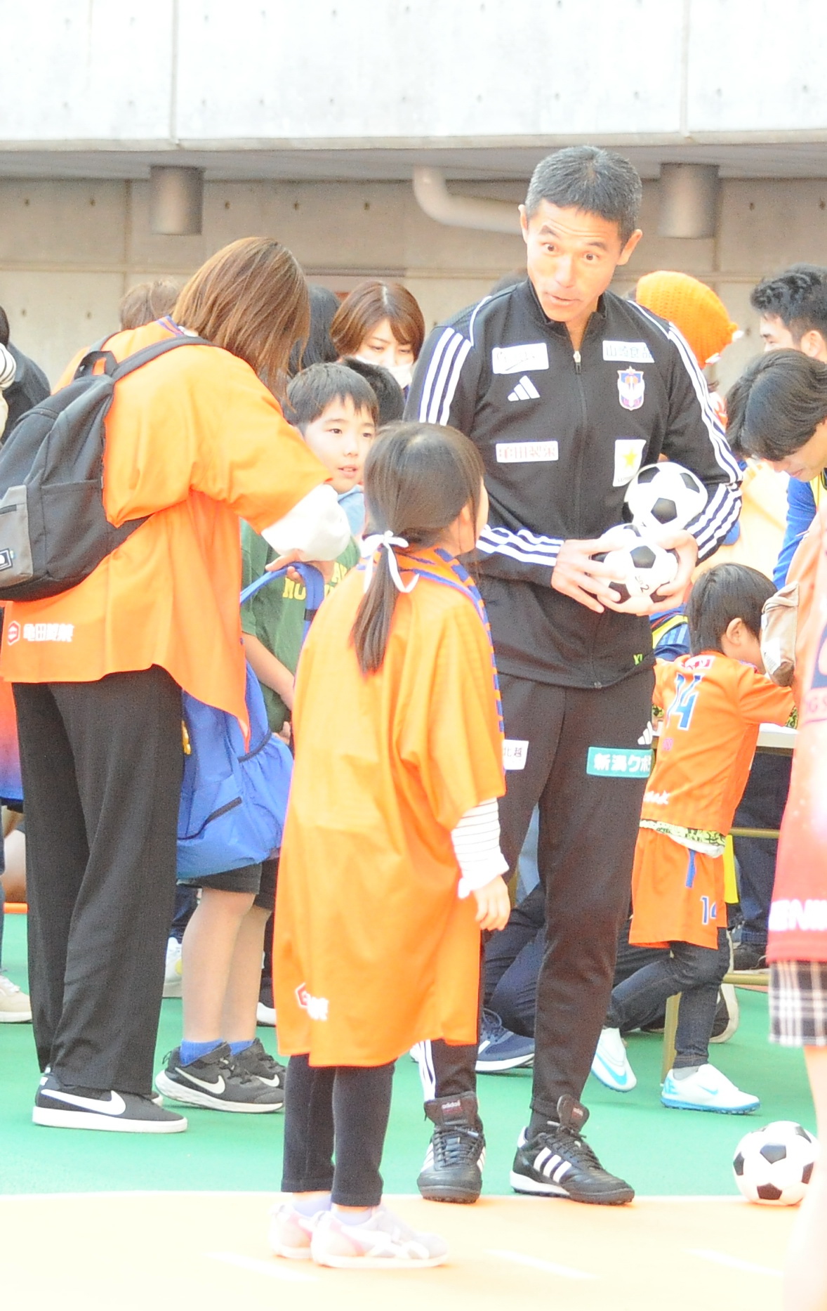 サンクスフェスタで子どもたちと笑顔で交流する新潟・松橋監督（中央）