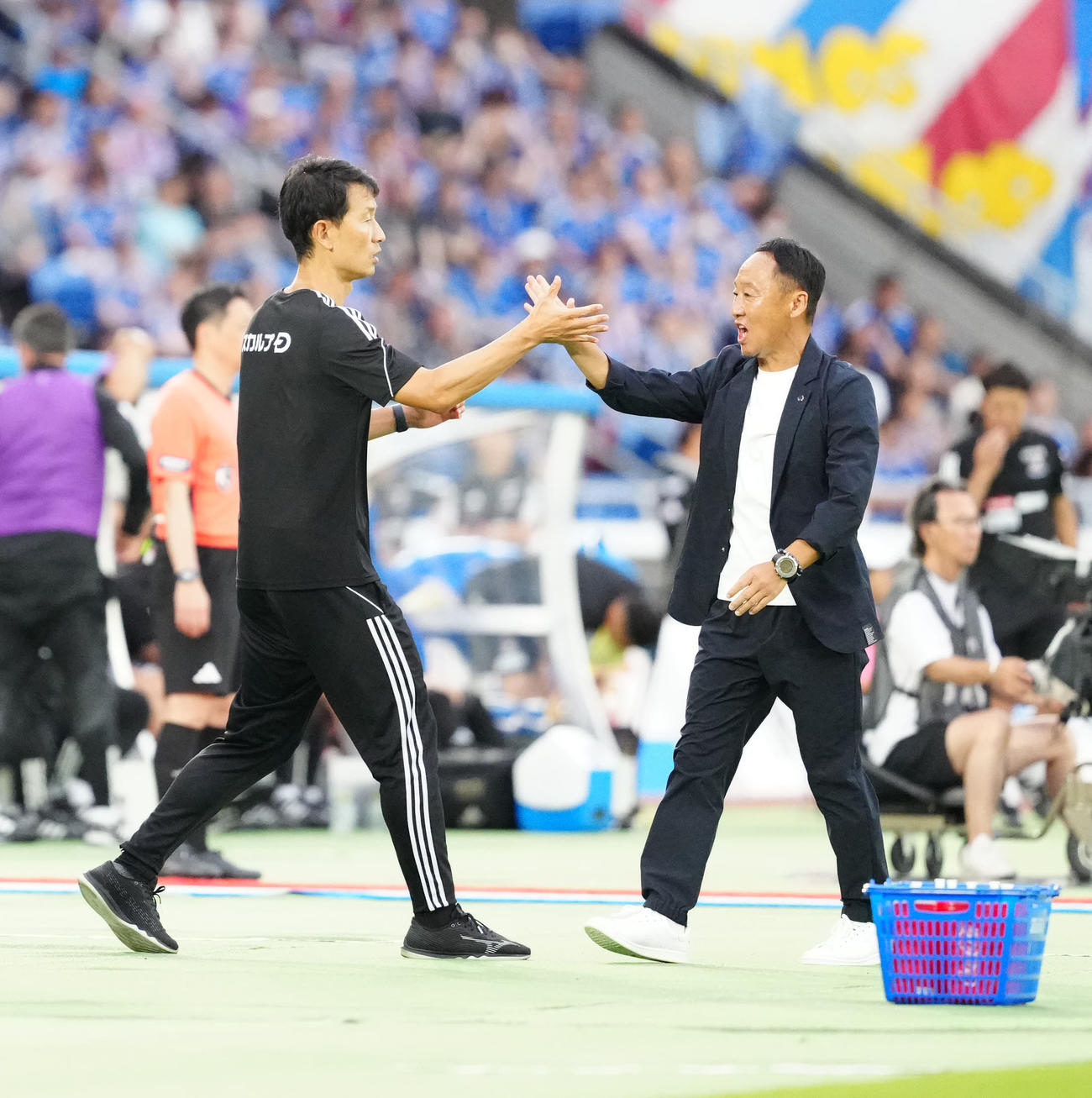 町田時代の金明輝ヘッドコーチ（左）とタッチを交わす黒田剛監督（2024年6月15日撮影）