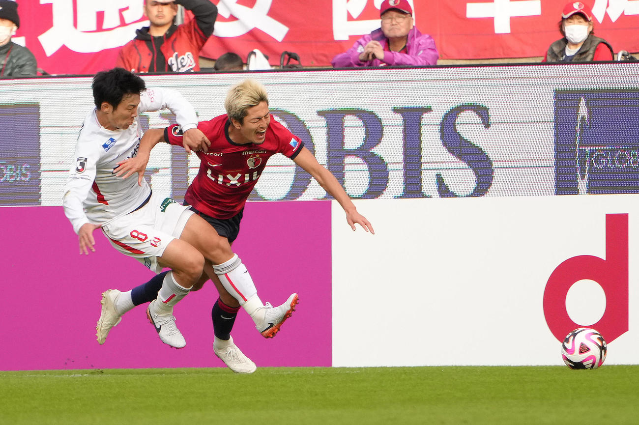 鹿島対名古屋　後半、名古屋椎橋（左）からファウルを受ける鹿島鈴木（撮影・足立雅史）