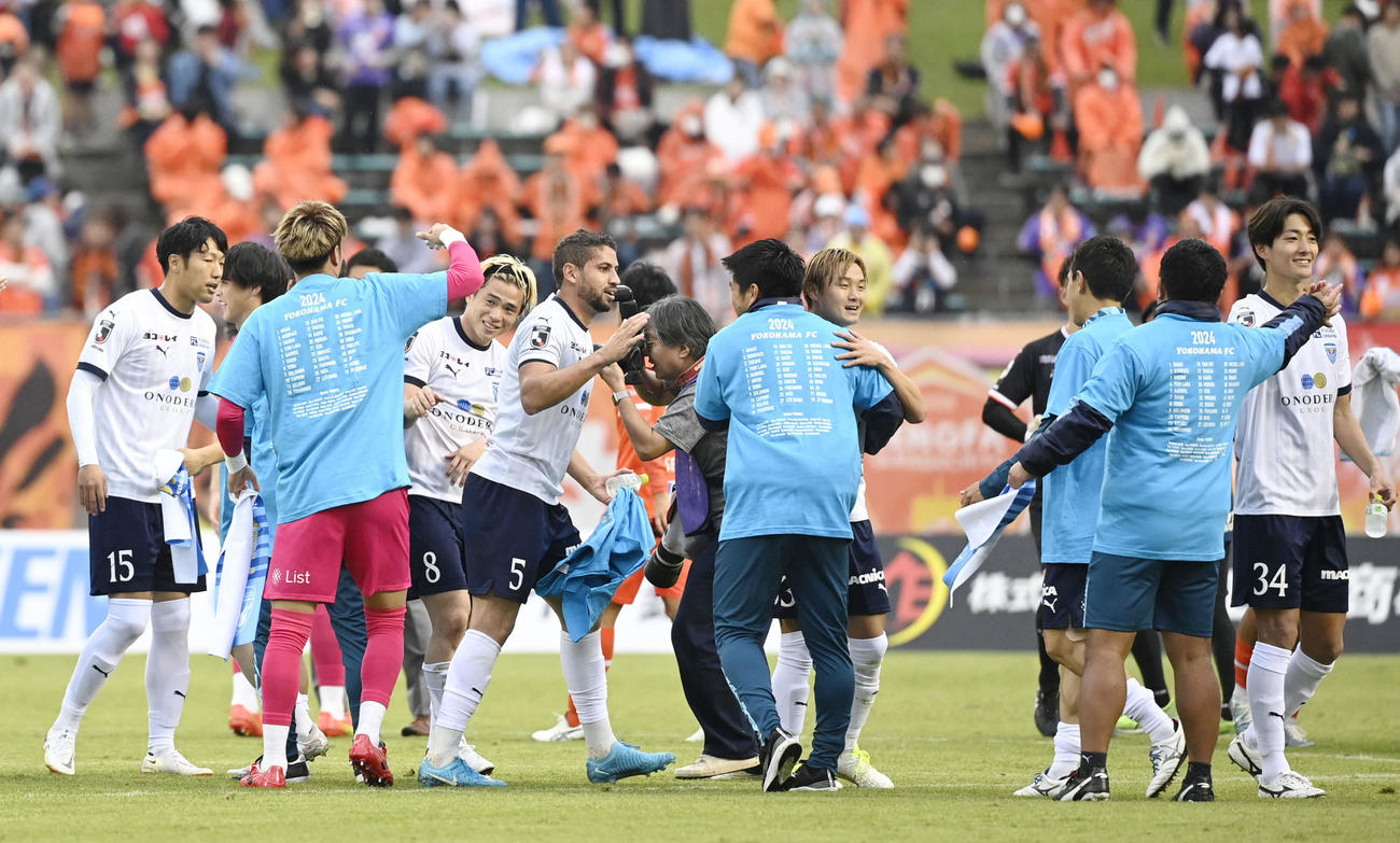 山口と引き分けJ1復帰を決め、タッチを交わす横浜FCの選手たち＝みらスタ（共同）